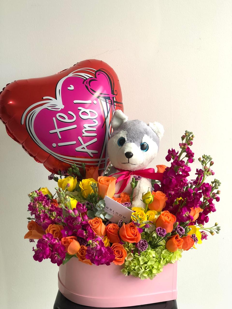 Caja en forma de corazon con flores variadas, peluche y globo según existensias