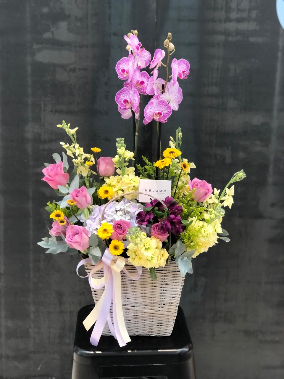 canasta con flores variadas y orquideas